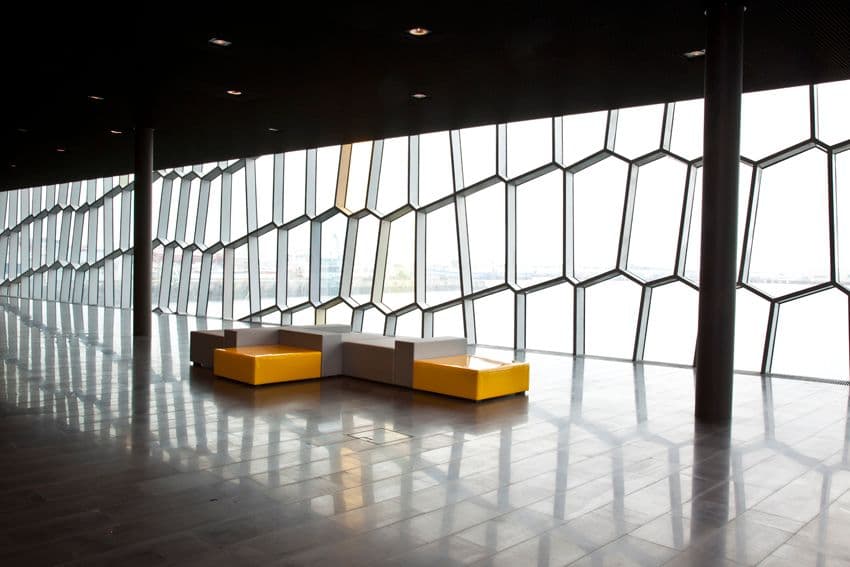 a large room with a lot of windows and yellow benches .