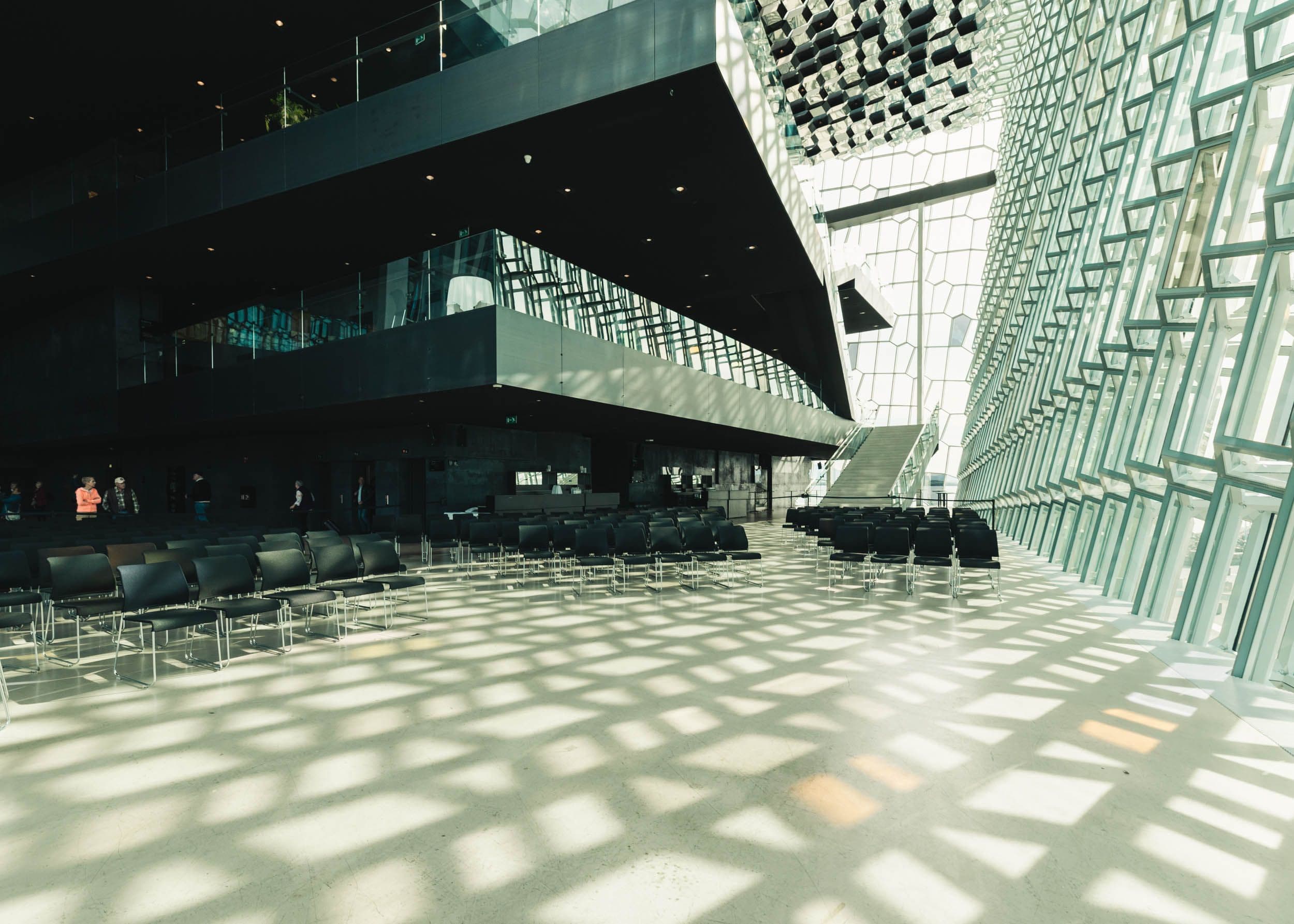 the inside of a large building with a lot of windows and chairs .